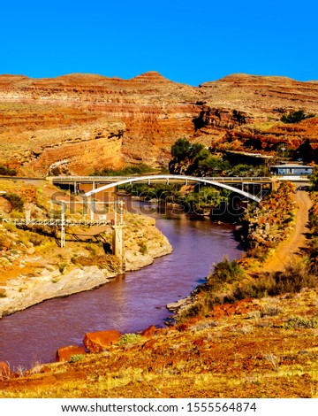 The red muddy San Juan River as it flows through the red sandstone landscape past the settlement of Mexican Hat at the northern edge of the Navajo Nation's borders in southern Utah, United States