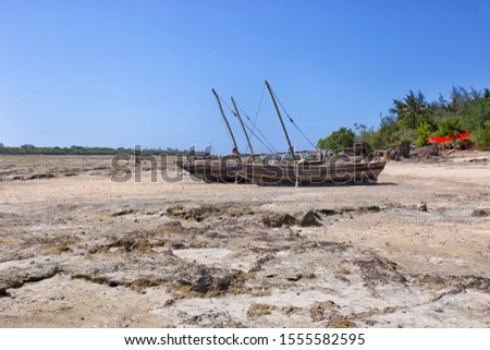 Fishing boat on the beach of Zanzibar waiting for the high tide to float into the ocean