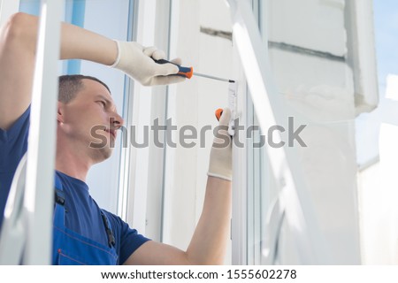 the master repairs the plastic window, warranty claim Royalty-Free Stock Photo #1555602278