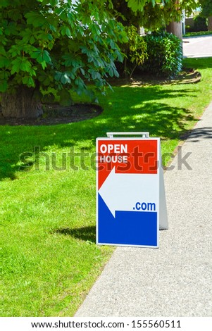 Real Estate Sign "Open House" on a pavement site.
