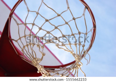 Basketball hoop with sky and clouds in uprisen angle view. Sport time