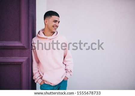 City portrait of handsome hipster guy wearing pink blank hoodie or hoody with space for your logo or design. Mockup for print