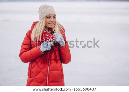 Blonde woman in red jacket outside in winter