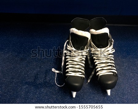Hockey skates in locker room floor over blue background with copy space. Top view