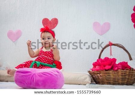 Little girl in red dress paper flowers and hearts, clenched fists on guard