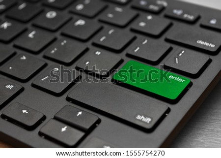 Black computer keyboard. The enter button is highlighted in green. Start the operation. Modern technologies.