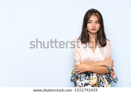 Caucasian girl with kimono over isolated blue background thinking an idea