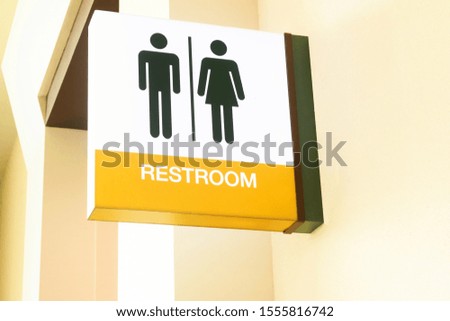 Yellow toilet or rest room sign on gray wall  with man, woman icon set  symbol background, modern, hygiene and clean restroom concept
