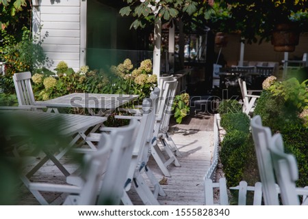 Patio with white chairs and trees