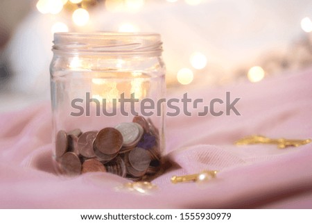 The money collected in the jar contains coins. A certain amount is accumulated for future spending. money saving growth to profit concept investment and finance business
