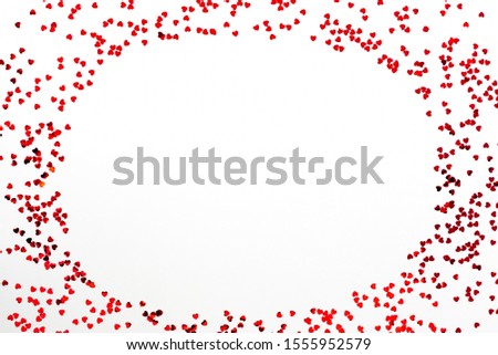 Valentine's Day background - a frame of scattered heart shaped confetti over white background.