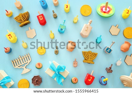 religion image of jewish holiday Hanukkah with menorah (traditional candelabra), spinning top over wooden blue background. top view, flat lay