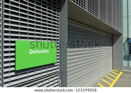 warehouse entrance with green deliveries sign