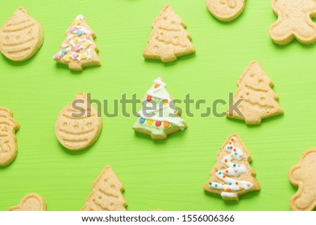 different shape Christmas cookies, Christmas trees with icing on a green background