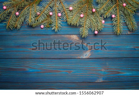 New Year's composition. Tree branches on a blue wooden background. Christmas tree decorated with berries. Christmas, winter, new 2020 year concept. Flat lay. Top view and copy space.
