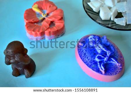 Set in the shape of soap and the basis for soap making on a blue background. 3D monkey, 2D fairy and Pansy flower.