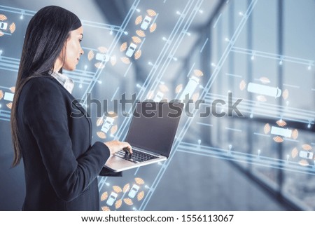 businesswoman holding laptop with creative map hologram on blurry city background.