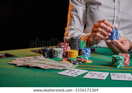 The croupier at the gaming table in the casino, raises bets with chips. Gaming business black jack, poker. With space for design.