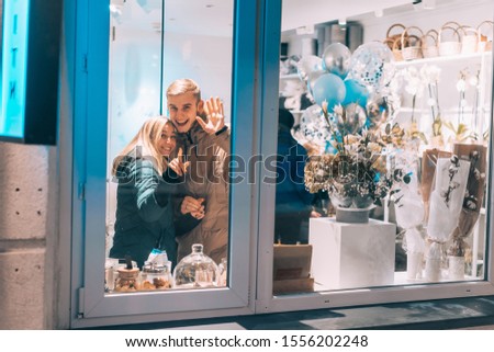 Photo through window. Young couple in cafe with stylish interior