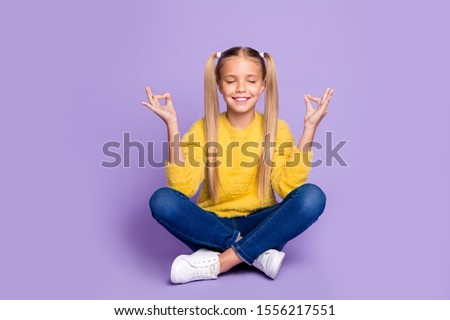 Full length photo of positive cheerful kid sit legs crossed folded train yoga meditate show om sign wear yellow casual style clothing isolated over violet color background