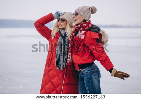 Mother and daughter together walking in park in winter