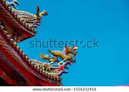 Traditional roof of Chinese temple. Dragon statue on the roof. Roof of the ancient temple of Buddhist temple called "Longshan" in Taipei, Taiwan.