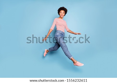 Full length profile side photo of sweet cheerful afro american girl jump go walk have rest relax wear casual style clothes isolated over blue color background