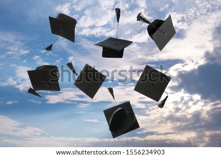 Throwing of mortar boards outdoors on Graduation Day Royalty-Free Stock Photo #1556234903