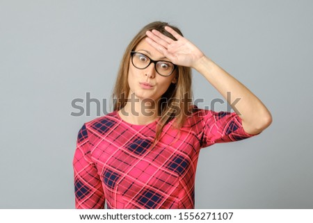 Portrait of emotive and funny woman wiping of sweat from forehead with tired and bothered expression