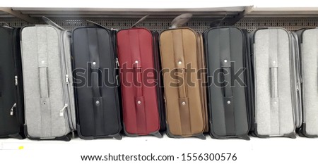 Multicolored suitcases standing in a row on the shelf in the store. The concept of travel and storage.