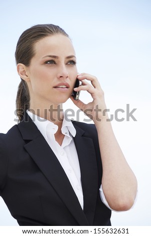 Young businesswoman on cellphone, looking away