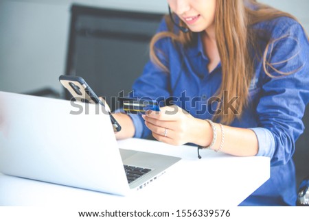 online shopping concepts. Woman hand  holding mobile phone and credit card with Payment Detail page display. using smartphone and laptop computer for online shopping 