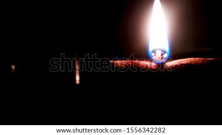 Close up image of a lit clay diya or lamp on floor on Diwali - an Indian hindu festival of lights isolated on black background.