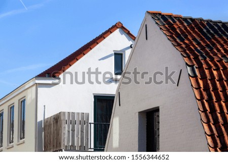Close up of old buildings with white walls and traditional red roof tiles in Vianen in the Netherlands