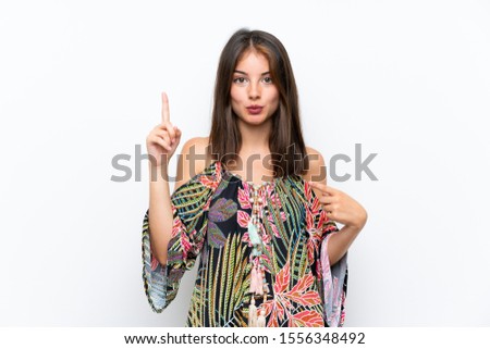 Caucasian young woman in colorful dress on isolated white background with surprise facial expression