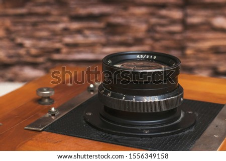 An old wooden camera of the last century with an accordion. Close-up camera lens.