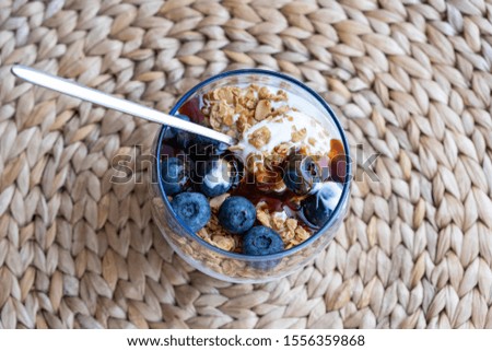 Granola parfait with yogurt and blueberries with maple syrup