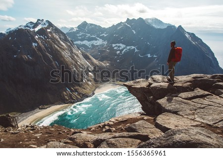 Man stand on cliff edge alone enjoying aerial view backpacking lifestyle travel adventure outdoor vacations