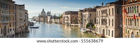 View of the Grand Canal and the stunning baroque Santa Maria Della Salute (1687) church in Venice and colourful villas bathed in early morning light. Stitched panoramic image. Royalty-Free Stock Photo #155638679