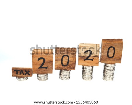 Concept of Tax Day 2020 on wood and stack of coins