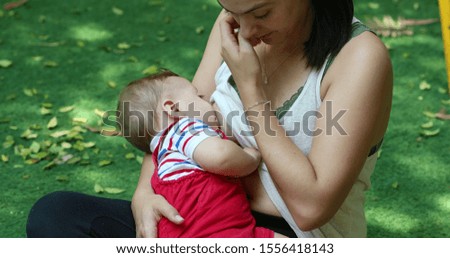 
Mother breastfeeding outside natural setting