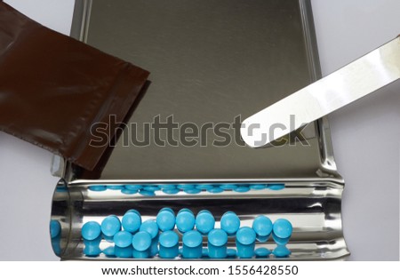 Blue medicine tablets in tray for counting in drugstore