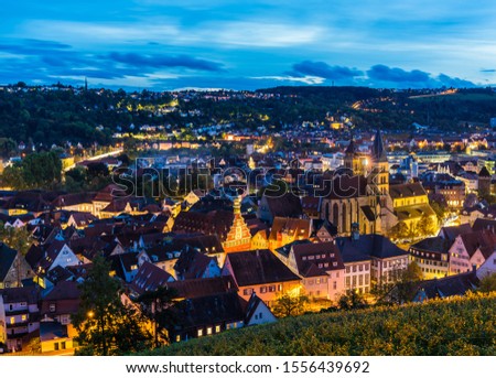 Germany, Skyline of medieval village esslingen am neckar, aerial view above roofs, houses, church and streets by night in magical twilight mood