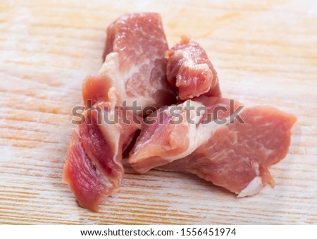 Image of tasty raw pork sliced before cooking at wooden surface, nobody
