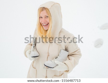 Happy winter fun woman. Happy young woman walking in winter time. Beautiful smiling young woman in warm clothing with ice skates