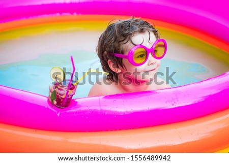 Cute kids relaxed and drink cocktail in swimming pool. Child boy and best swimming pool. Beach party. Healthy outdoor sport activity for children. Vacation at Paradise