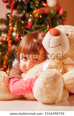 Christmas picture of little beautiful girl with a teddy bear  waiting for Christmas and Santa Claus