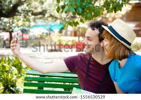Happy young tourist couple taking selfie with mobile phone in the city. Fun concept.