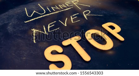 winner never stop motivational thoughts written with chalk on black board 