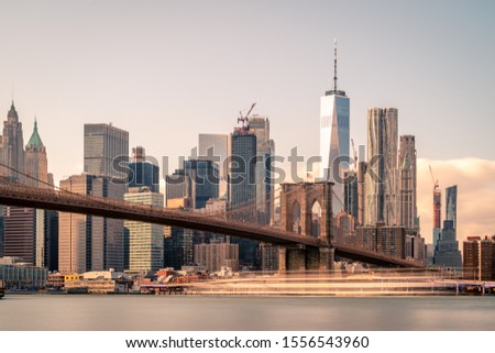 Brooklyn Bridge in front of Lower Manhattan.  Daytime Long Exposure, smooth water.
